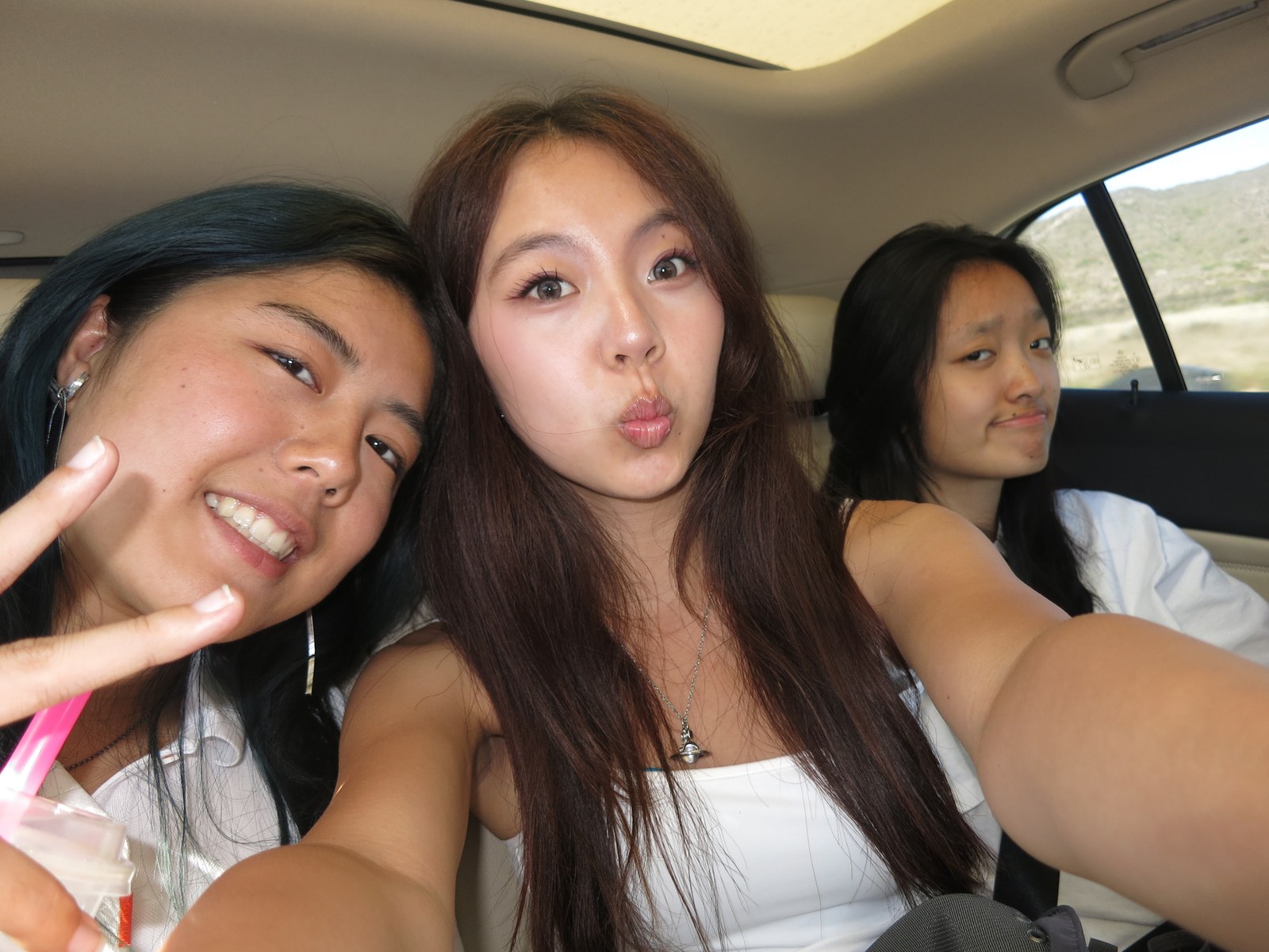 Three friends taking a selfie in the car mid-roadtrip