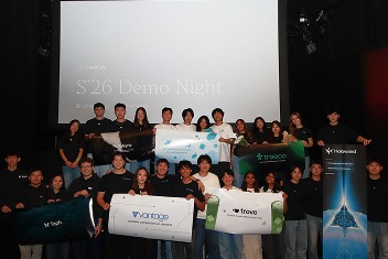 Group photo on stage at LavaLab's demo night, teams and their project banners lined up behind them