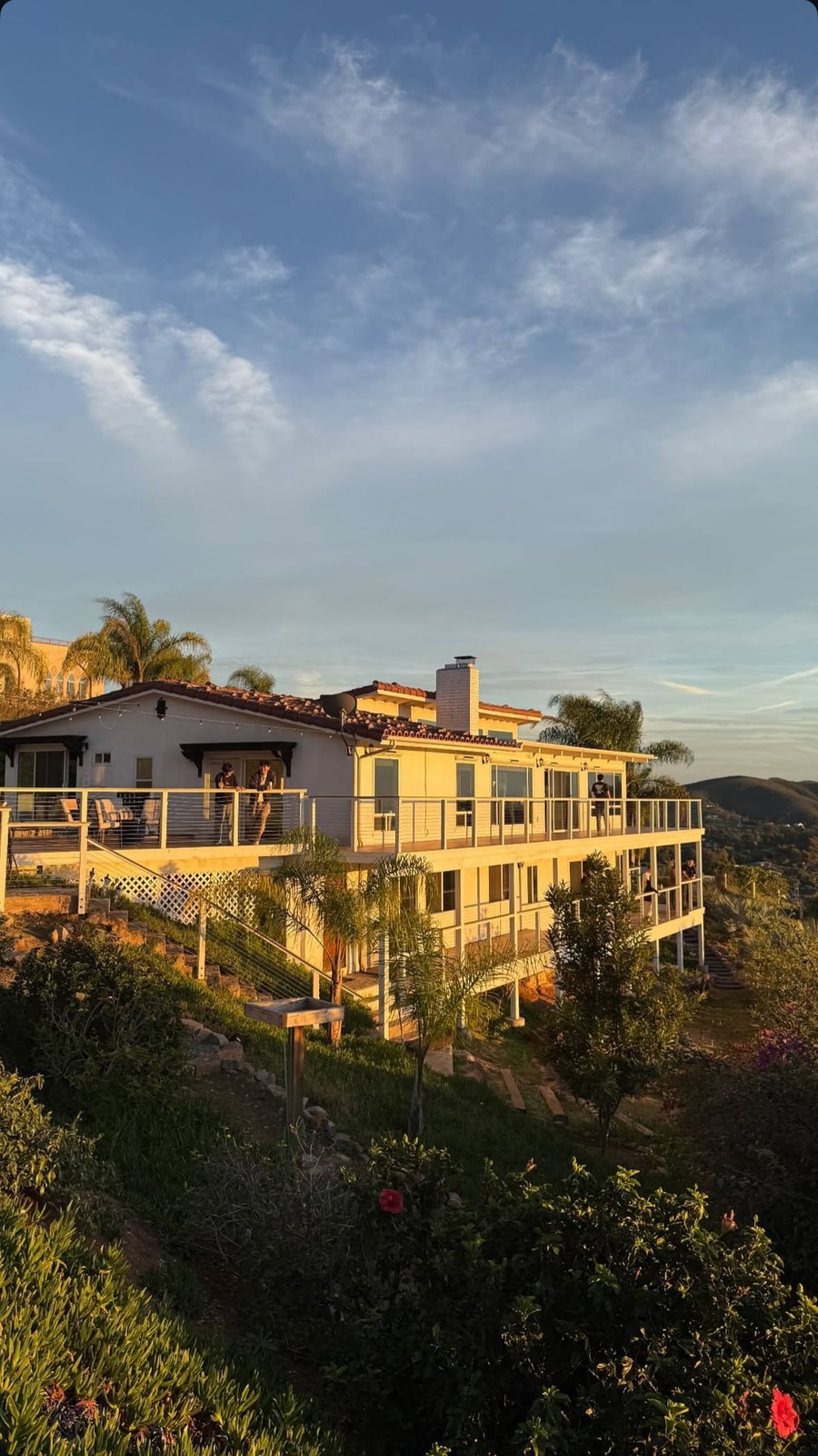 A cliffside house looking out over the ocean at dusk
