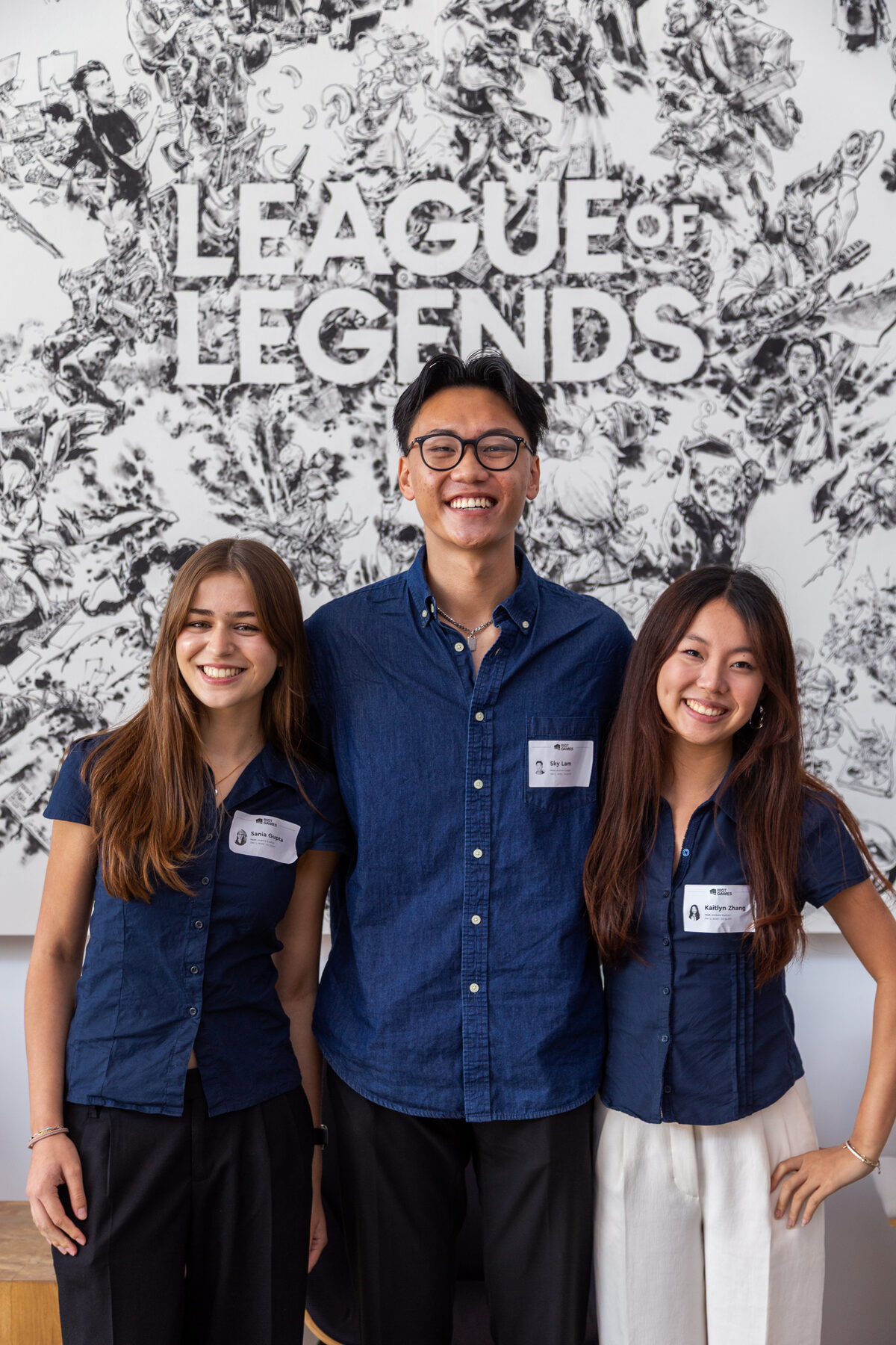 Sania Gupta, Sky Lam, and Kaitlyn Zhang in front of the League of Legends wall at Riot Games